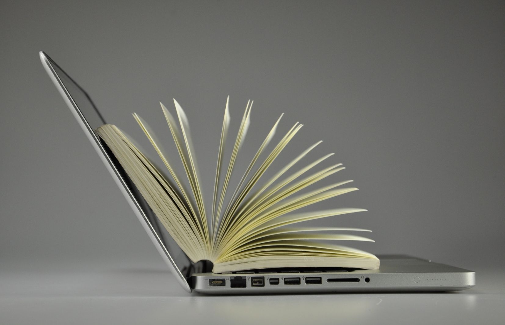 Imagem de um caderno saindo de um computador para ilustrar um dicionário de apostas