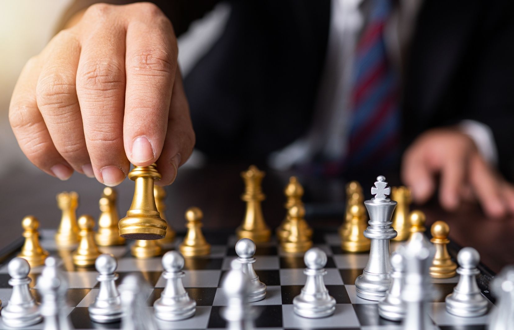 Pessoa jogando jogo de xadrez, simbolizando o tópico de estratégias eficazes para ganhar dinheiro com apostas de arbitragem esportiva