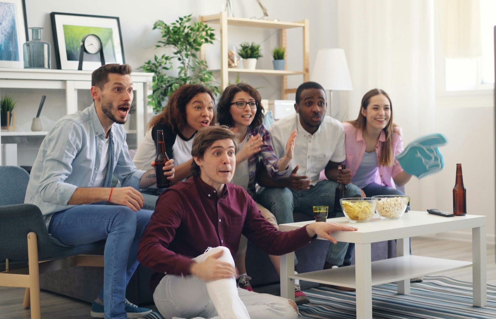 Pessoas torcendo por uma partida em tempo real, simulando apostas ao vivo